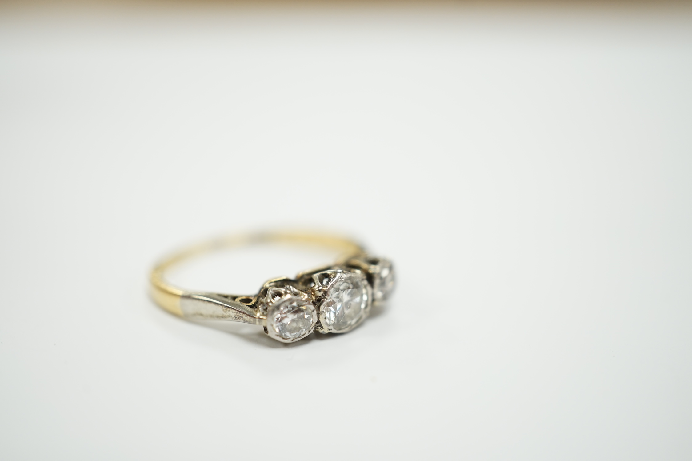 An 18ct and illusion set three stone diamond ring, size I, gross weight 2 grams.